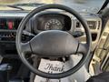 Steering wheel and dashboard of a 2008 Suzuki Carry featuring speedometer and control dials with a thank you mat on the floor