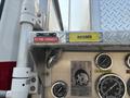 A close-up view of a 1999 Freightliner FL80's control panel featuring labeled switches for foam and hosebed with pressure gauges and discharge indicators