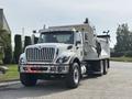 A white 2013 International WorkStar truck with a large dump bed and multiple headlights parked on a paved area