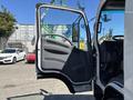 A 2022 Isuzu NQR with its driver-side door open, showcasing the interior cabin and seat area