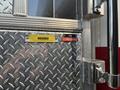 Close-up of a metal door panel on a fire truck labeled with the words HOSEBED and a red label that reads FOAM #1 PRE-CONNECT