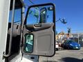 A white 2020 Peterbilt 330 truck with its driver's door open showcasing the interior and cabin design