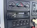 Dashboard controls and stereo system of a 2008 International 7500 featuring knobs for climate control and a Panasonic radio with buttons below for various functions