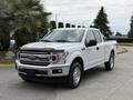 A white 2018 Ford F-150 pickup truck with a sleek design and chrome grille facing forward