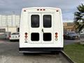 A white 2002 Ford Econoline van with a plain rear design featuring two large windows and red tail lights