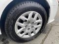 A close-up of a silver alloy wheel with a Bridgestone tire on a 2014 RAM Cargo Van featuring five circular spokes