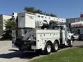 A white 2013 International 7400 bucket truck with an Altec aerial lift mounted on the back and utility storage compartments on the sides