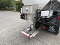 A rear view of a 2012 International TerraStar truck with a mounted salt spreader featuring a silver metal hopper and a motor attached at the base