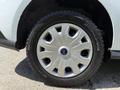 Close-up of a silver wheel with a multi-spoke design mounted on a black tire featuring the brand name Firestone on its side