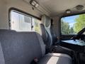 Interior of a 2009 Kenworth T270 showing a gray upholstered driver's seat and a passenger seat with a flat plastic surface for mounting equipment
