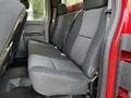 A red 2013 Chevrolet Silverado 3500HD with a spacious back seat featuring grey cloth upholstery and a simple interior design