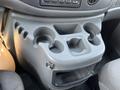 A gray cup holder console featuring multiple cup holders and a small storage compartment in a 2005 Ford Econoline