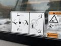 Instructional stickers for operation of a Caterpillar TL1055C telehandler showing control directions and safety warnings