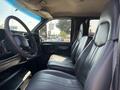 A 2005 GMC C7500 Topkick featuring a driver side view of the interior with two black leather seats and a steering wheel visible
