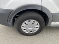 A close-up view of a tire and wheel of a 2024 Ford Transit showing the silver alloy rim and black tire tread