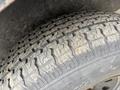 A close-up view of a worn tire with a detailed tread pattern showing signs of use and age