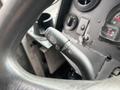 A close-up view of the steering column controls in a 2012 Ford E-450 Super Duty featuring turn signal and headlight switch indicators