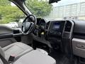 Interior of a 2018 Ford F-150 showing the driver's seat dashboard and controls with a focus on the center console and various buttons and displays