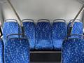 Interior of a 2018 Grande West Vicinity bus featuring rows of blue fabric seats with a star pattern and metal grab bars above