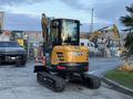 A yellow and black 2023 Sany SY35U mini excavator with a cab and tracks positioned on a paved surface