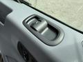 Close-up of the door handle and control button of a 2017 Ford Transit showing a textured surface and ergonomic design