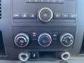 Control panel of a 2013 Chevrolet Silverado 1500 featuring climate controls audio controls and various knobs and buttons