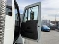 A 2011 International 4300 truck with its driver's side door open showing the interior and rearview mirror