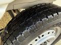 A close-up of a black tire from a 2008 Suzuki Carry showing the tread pattern and metal rim