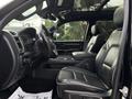 Interior of a 2021 RAM 1500 showcasing black leather seats and modern dashboard features with a steering wheel and gear shifter visible