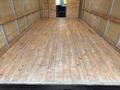 2024 Ford E-450 empty cargo space with wooden floor and walls lined with metal framing