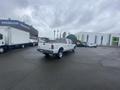 A white 2005 Ford F-350 SD truck with a long bed and dual rear wheels parked on a paved surface