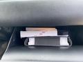 The image shows the glove compartment of a 2022 Kia Sorento containing documents and a black binder