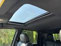 A sunroof in the cabin of a 2018 RAM 3500 with black leather seats and a spacious interior design