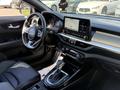 Interior view of a 2024 Kia Forte5 showing the steering wheel dashboard touch screen and gear shift with modern design elements and controls