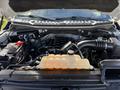 The engine compartment of a 2018 Ford F-150 showing the engine block battery and coolant reservoir