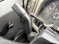 Close-up of a black gear shift lever inside a 2013 International Workstar 7500 truck cabin with various controls and gauges visible in the background