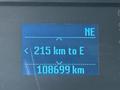 A digital display showing a navigation screen with a distance of 215 km to the east and an odometer reading of 108699 km