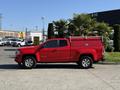 A red 2018 GMC Canyon pickup truck with a matching cap on the bed parked on a concrete surface