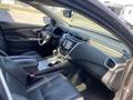The interior of a 2017 Nissan Murano featuring a black leather steering wheel and seats a central touchscreen display and various control panels on the dashboard