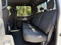 Interior view of a 2018 Ford F-150 showing the rear seating area with gray upholstery and seat belts