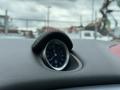 Dashboard clock of a 2016 Maserati Ghibli with a round face and silver detailing set in a black leather surround