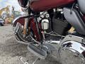 A 2009 Harley-Davidson Road King showcasing its chrome engine and footpeg with a dark red body and iconic styling features