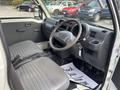 Interior of a 2010 Daihatsu Hijet showing front seats dashboard steering wheel and gear shift with a thank you mat on the floor