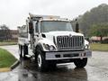 A 2011 International 7500 dump truck with a white body and silver trim featuring a large front grille and orange lights on the roof