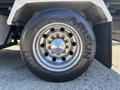 A close-up view of the chrome wheel and tire on a 2020 Peterbilt 330 showcasing the tire tread and wheel design