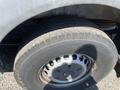 A close-up of a 2016 Mercedes-Benz Sprinter tire with visible tread and a silver wheel rim