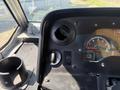 The dashboard of a 2012 Ford Econoline showing dials and controls including air vents a gear selector and a cup holder