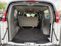 Interior view of a 2004 Chevrolet Express showing a spacious cargo area with gray upholstery and a folding rear seat