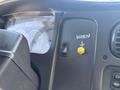 Close-up of the dashboard of a 2014 Freightliner M2 106 featuring a horn button labeled with an arrow indicating off and a yellow button