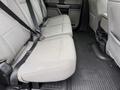 The interior of a 2020 Ford F-550 showing the back seat with gray fabric upholstery and seat belts